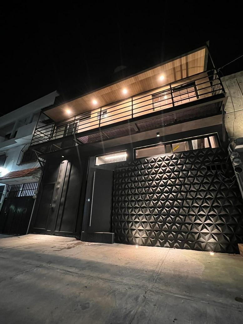 Exterior view of the modern black facade at Punto de Negocios, 140 Prof. Jesús Romero Flores.
