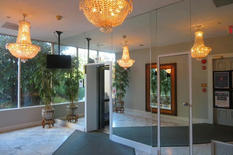 Elegant lobby featuring crystal chandeliers, large mirrors, and indoor plants.
