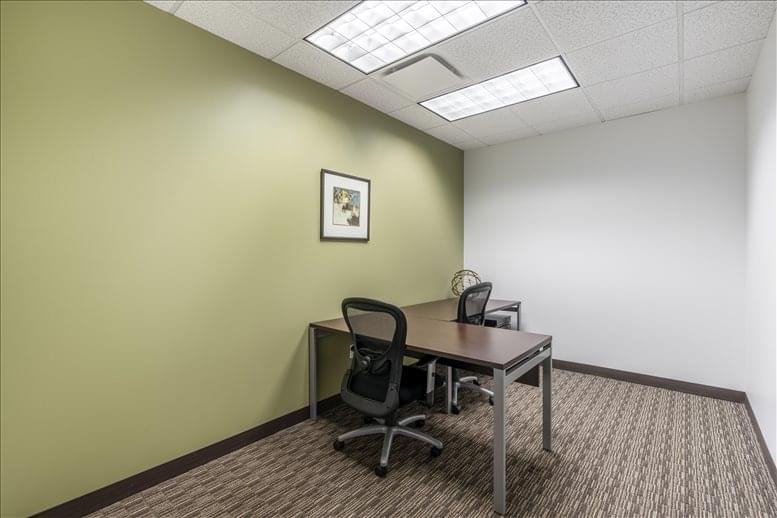 Small office with two desks and green accent wall.