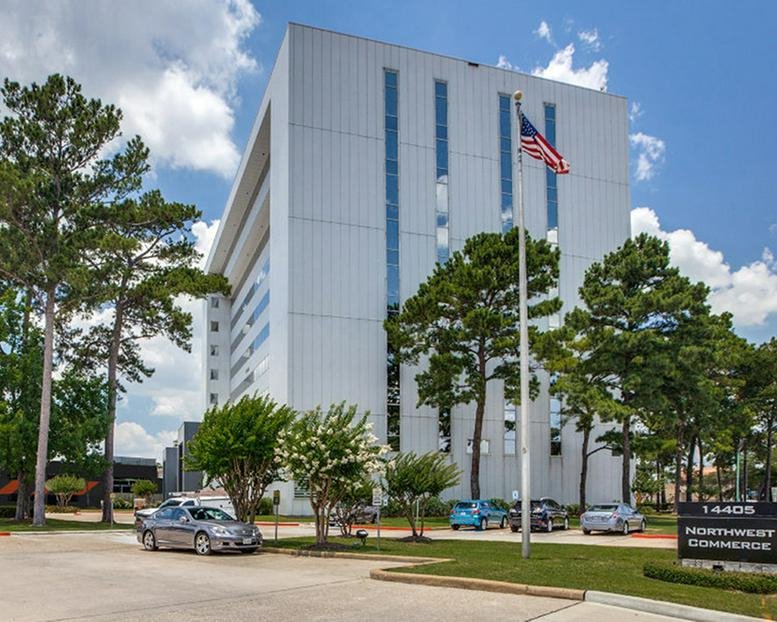 Exterior view of the white Northwest Commerce building at 14405 Walters Road under a bright sky.