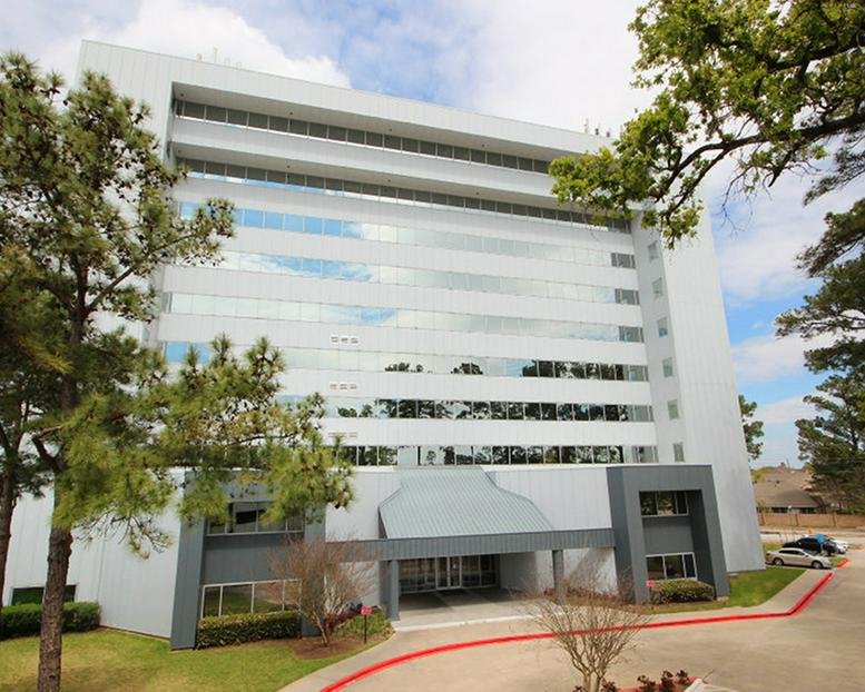 Wide exterior shot showing the front entrance and glass facade of the office complex.