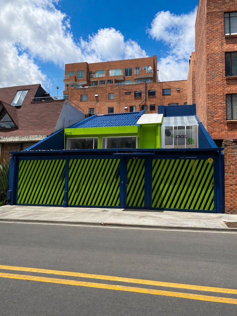 Exterior view of the blue and lime green facade at DGL Cowork Cedritos, Carrera 13a #145-26.
