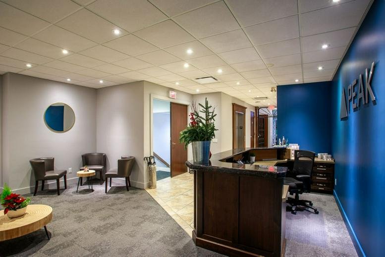 Professional reception area at 1455 Ellis Street, Downtown Kelowna with dark wood desk and blue feature wall.