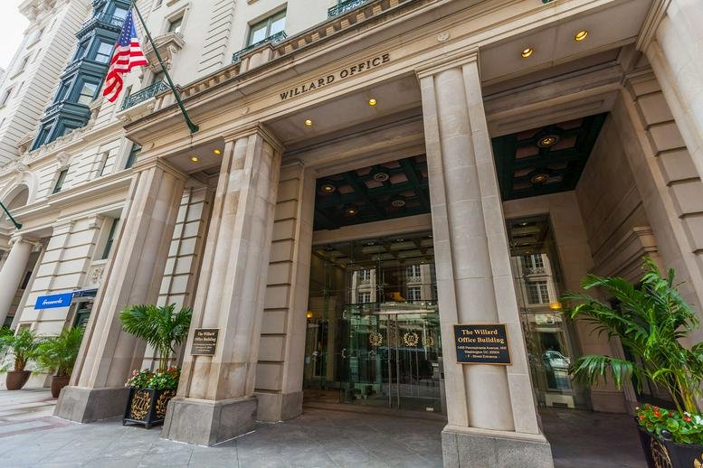 Grand stone entrance and facade of the Willard Office Building at 1455 Pennsylvania Avenue NW.