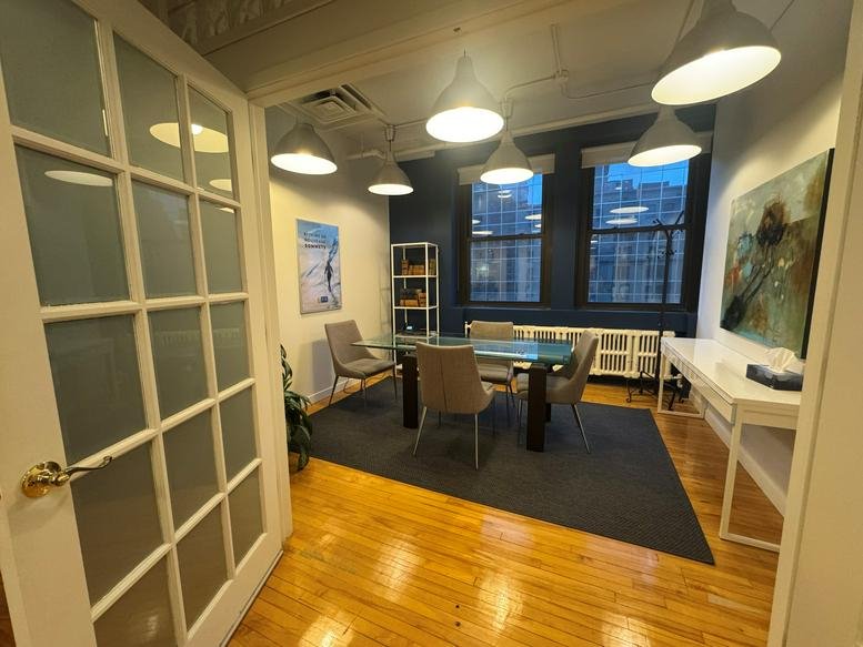 Spacious meeting room at the Hermes Building with a glass table, blue feature wall, and large windows.