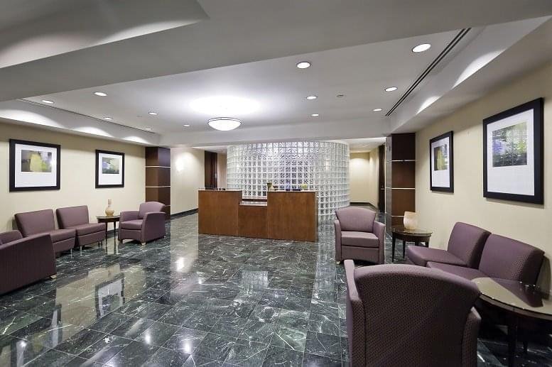 Grand reception lobby at Independence Place featuring marble floors and a wooden welcome desk.