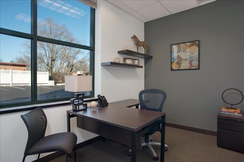 Private office with large window and L-shaped desk.