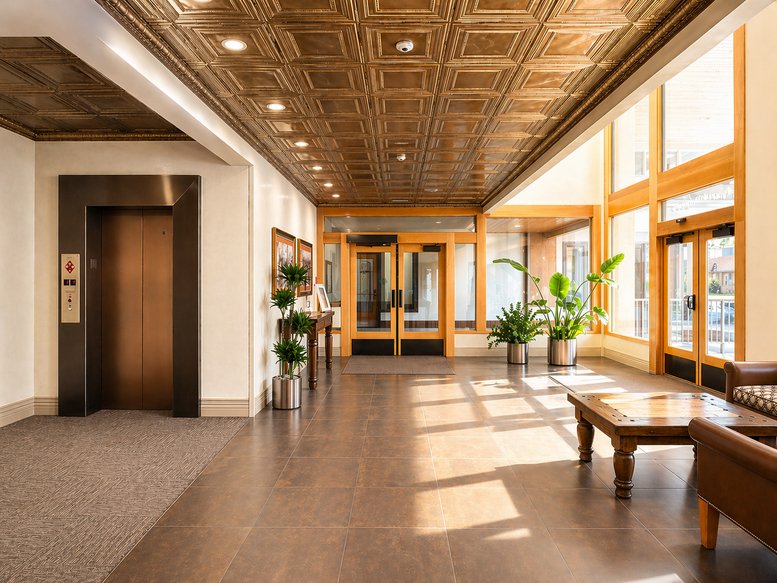 Heritage Ascent lobby with a decorative tin ceiling, wood floors, and bright natural light.