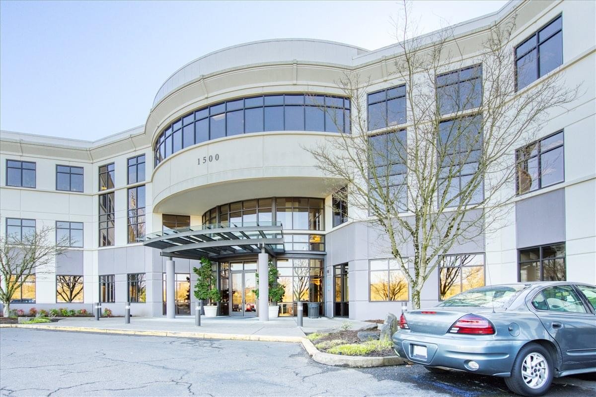 The grand exterior facade and curved glass entrance of 1500 NW Bethany Boulevard, Suite 200.