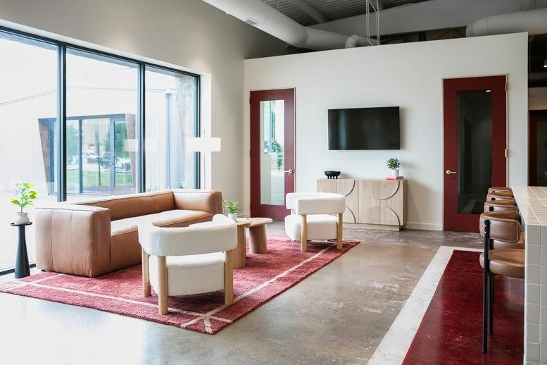 Spacious sun-drenched lounge at 1516 North Durham Drive featuring leather sofas and velvet chairs.