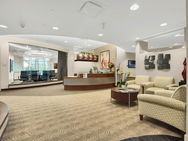 Spacious reception area with a curved wood-panelled front desk at 1540 International Parkway, Suite 2000.
