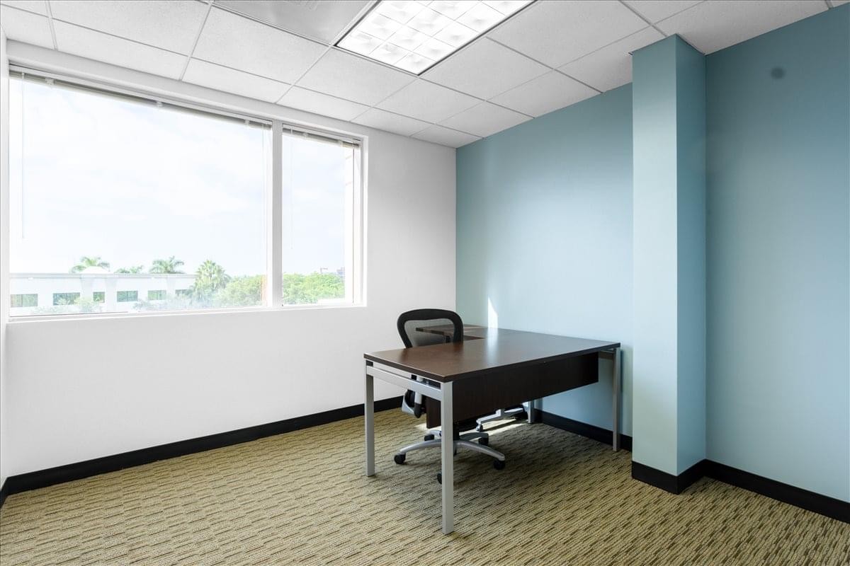 Bright private office at 1560 Sawgrass Corporate Parkway with a large window and blue accent wall.