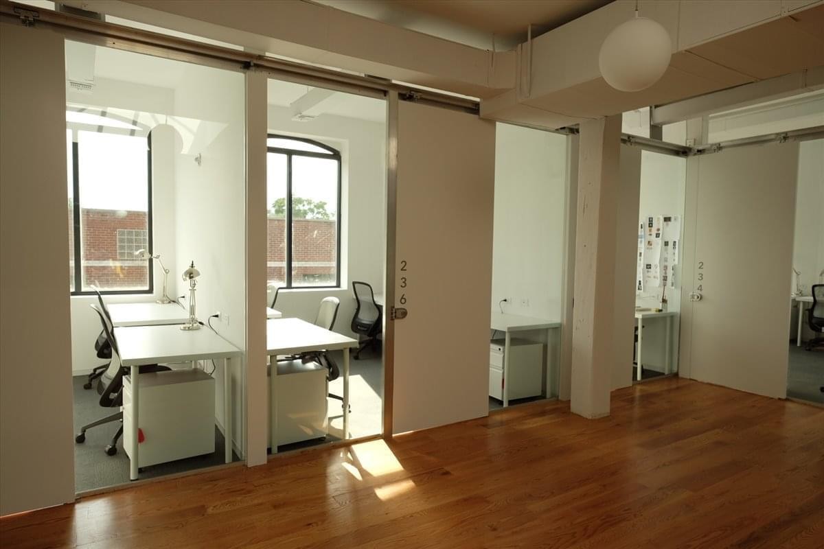 Spacious interior workspace with wooden floors and private glass-partitioned offices at 157 13th Street, Gowanus.