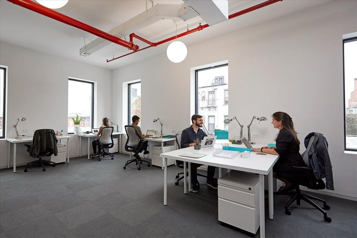 Spacious open-plan workspace at 157 13th Street, Gowanus, New York City with natural light and red pipes.