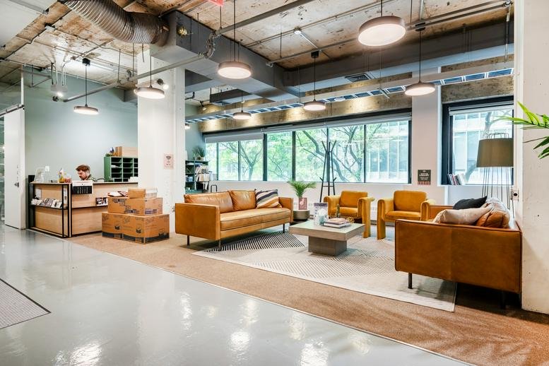 Spacious reception area and lounge at 157 Columbus Avenue with leather sofas and industrial ceilings.