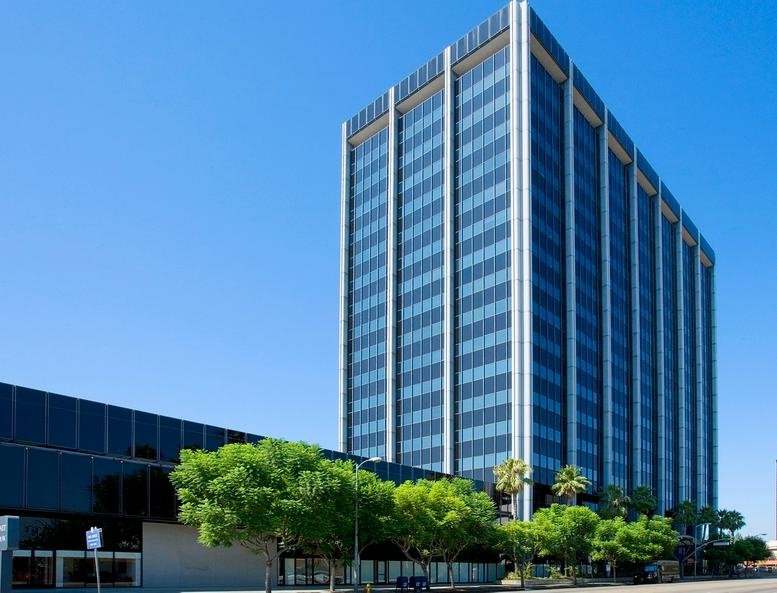 Exterior view of the multi-story Wells Fargo Bank Building with glass facade and blue sky.