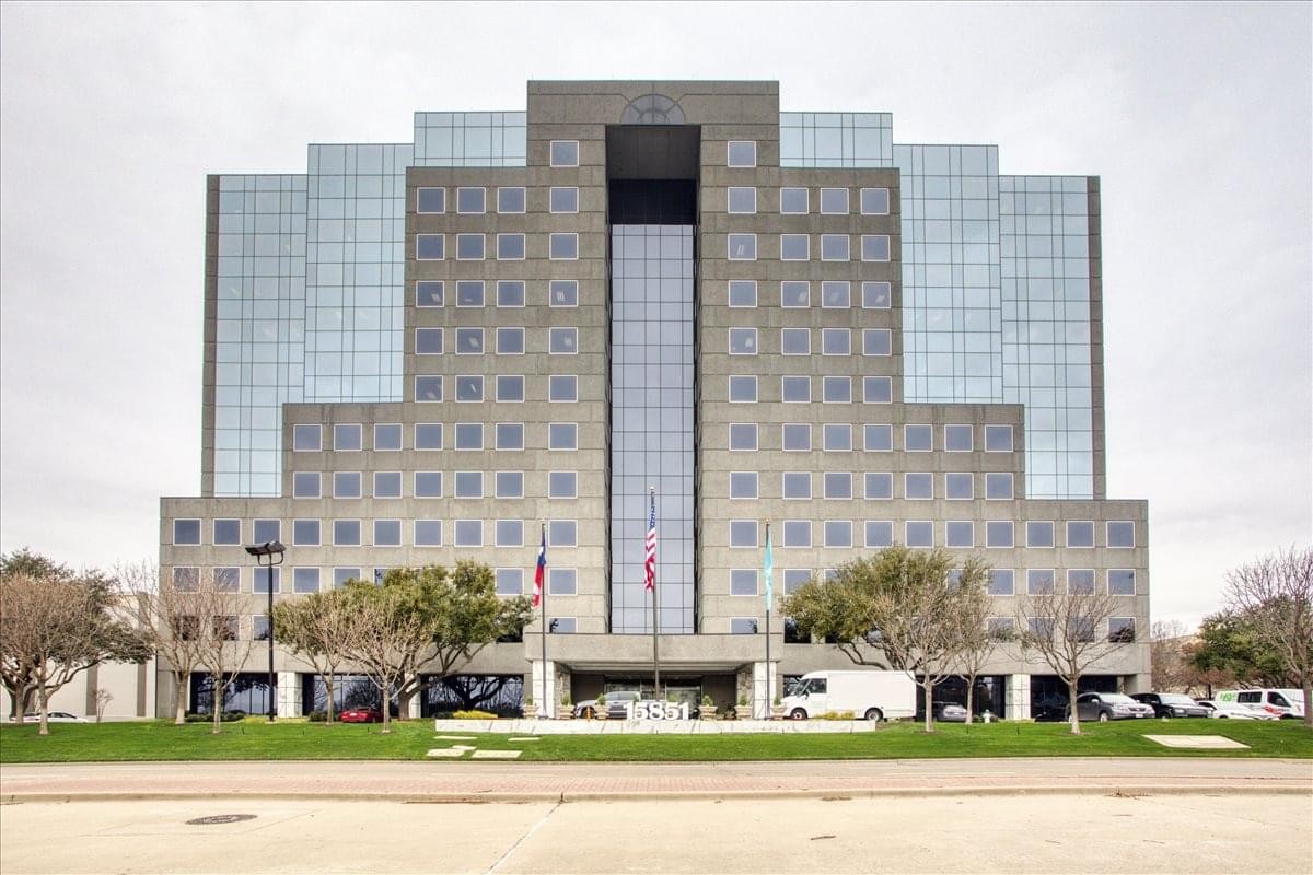 Symmetrical exterior facade of The Madison Business Center with a central glass column.