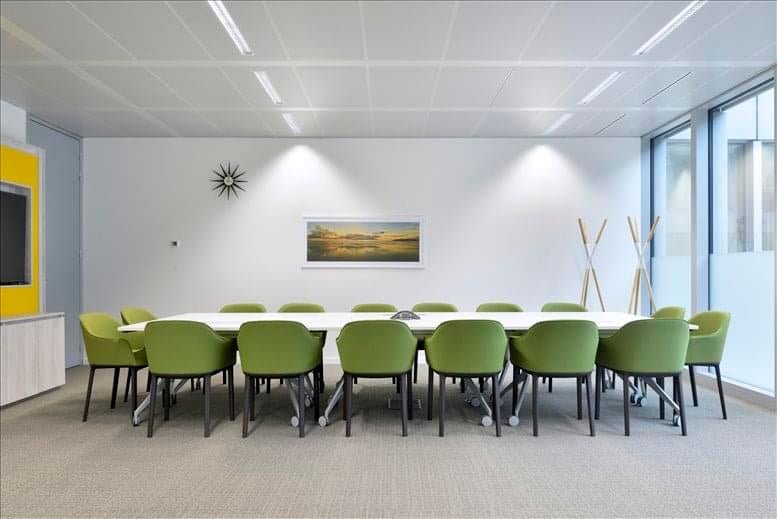 Spacious boardroom at 1600 Riviera Avenue, 2nd Floor featuring green armchairs and a long white table.