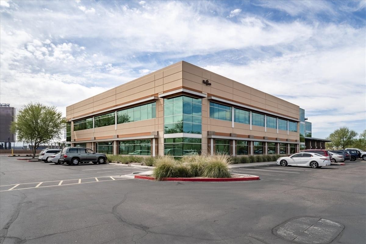 Exterior view of the professional Peoria Center at Arrowhead building with large glass windows and parking.