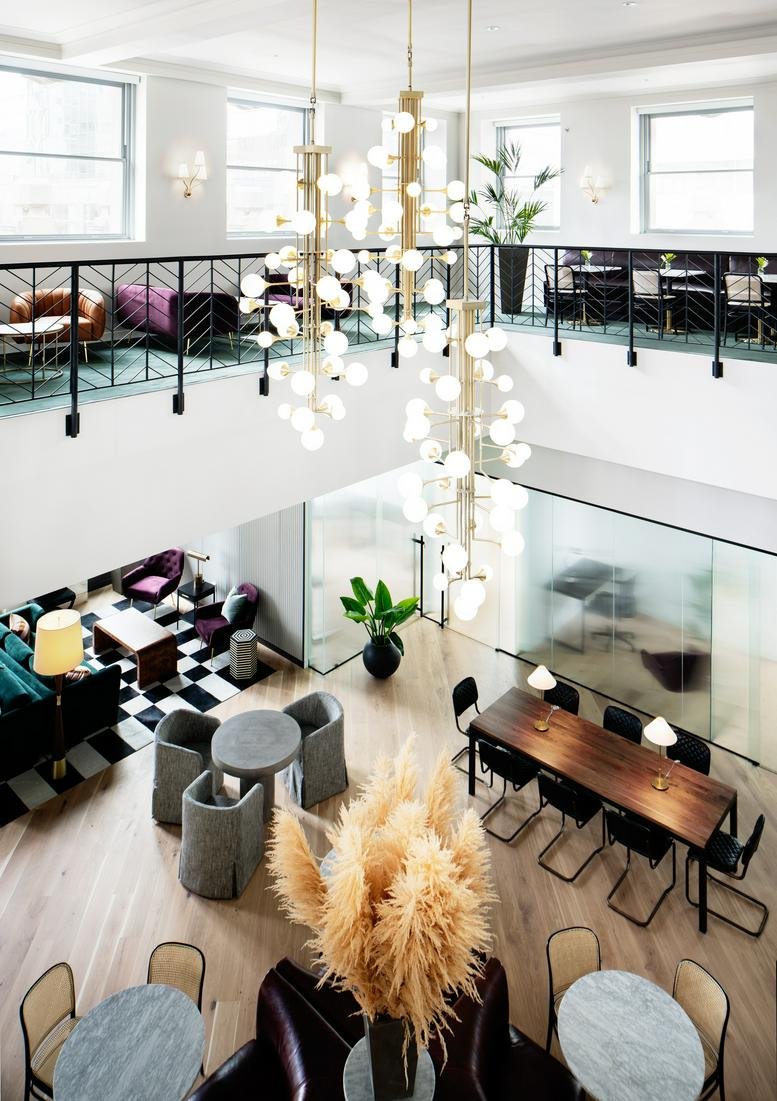 Spacious bi-level lounge with modern chandeliers and plush seating at 1617 JFK Boulevard.