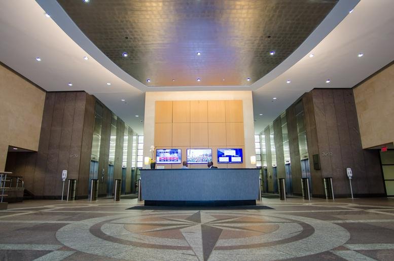 Grand entrance lobby at 1700 Market Street with high ceilings and a central compass floor design.