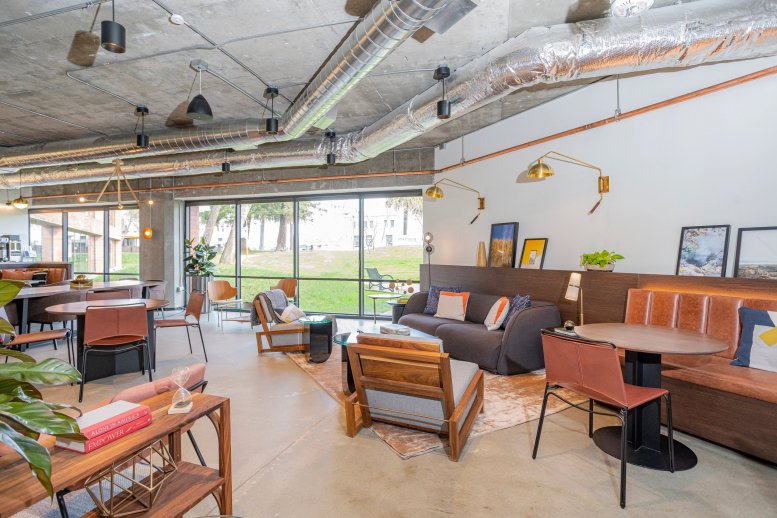 Open-plan coworking area at 1700 Montgomery St featuring varied seating and large windows.