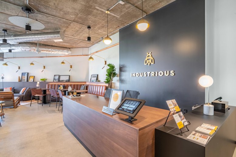 Branded reception area at 1700 Montgomery St featuring a sleek wood desk and gold logo.
