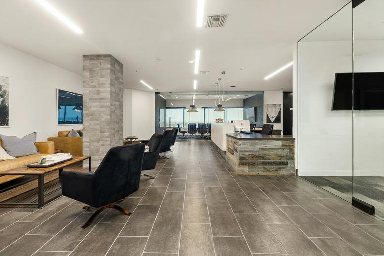 Spacious lobby and lounge at Huntington Beach Plaza with modern seating and stone pillars.