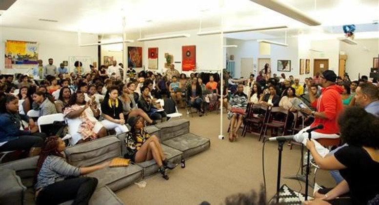 Spacious communal lounge and event space at 1721 Broadway, Suite 201 with tiered seating and art-filled walls.