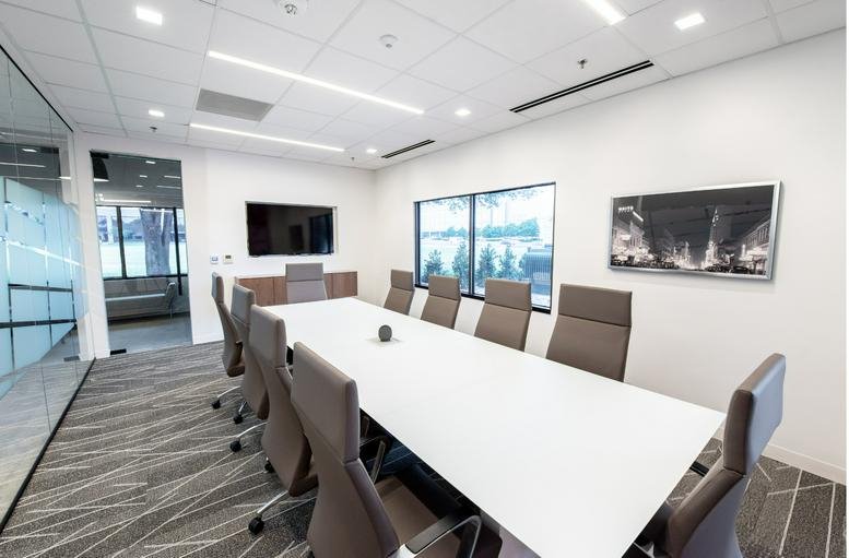 Spacious board room at 17250 Dallas Parkway with a long white table and modern ergonomic chairs.