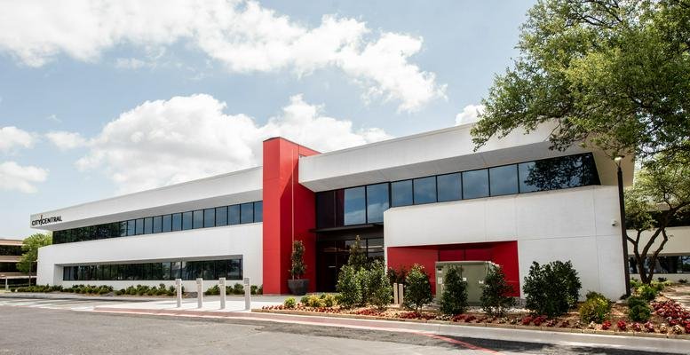 Modern exterior of Venture X Dallas-Addison, 17250 Dallas Parkway with a bold red architectural feature.