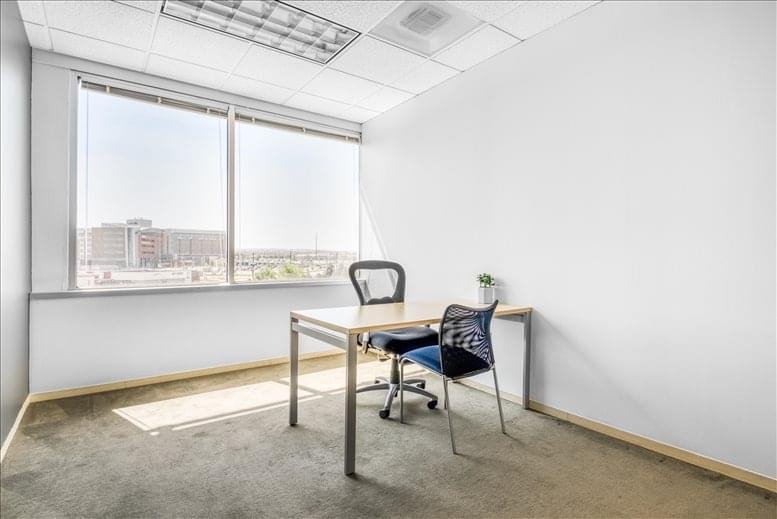Internal single office with a desk and a large window view.