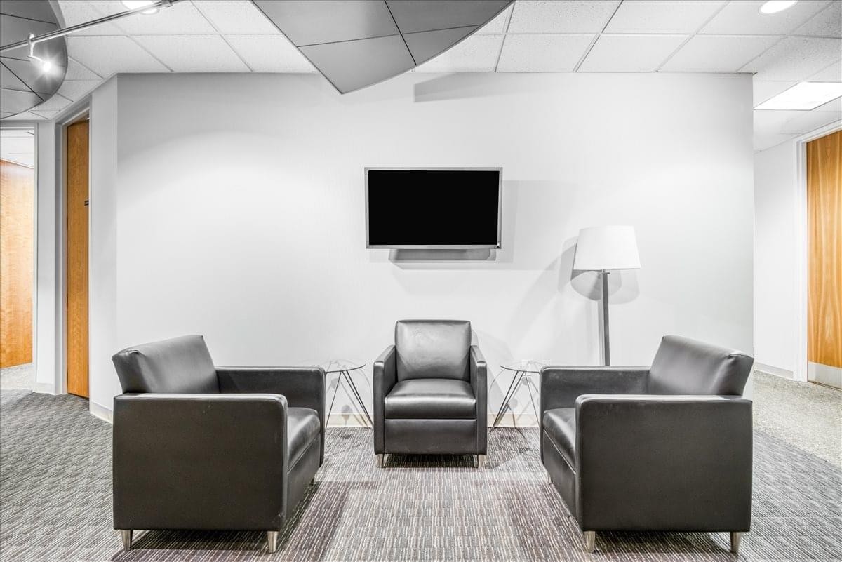 Reception lounge area at 1745 Shea Center Drive, Suite 400 with black leather armchairs and TV.