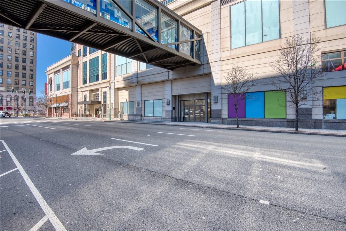 Street view showing the elevated walkway of the Trump Plaza building.