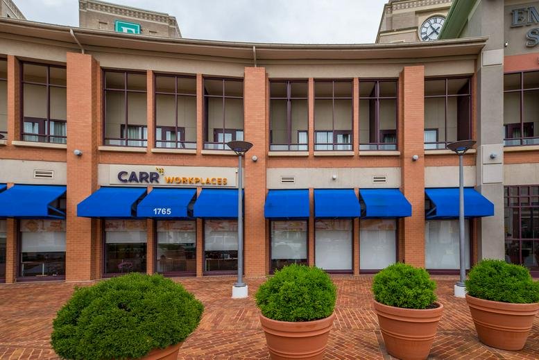 Exterior view of the brick facade and blue awnings at 1765 Duke Street.