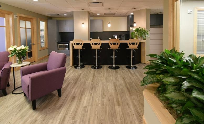 Spacious reception lounge at 1775 I Street NW, Suite 1150 with purple armchairs and a modern kitchen island.