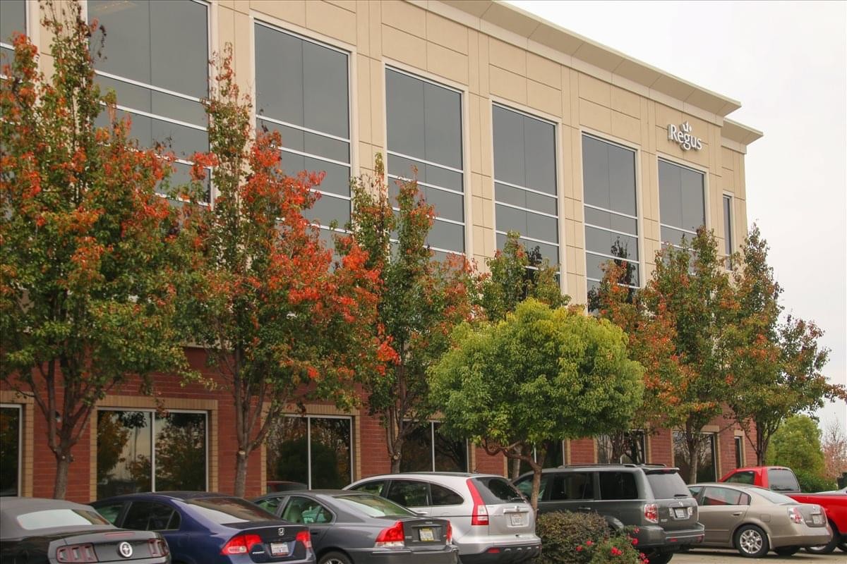 The multistory office building exterior at 180 Promenade Circle, Suite 300 with colorful autumn trees.