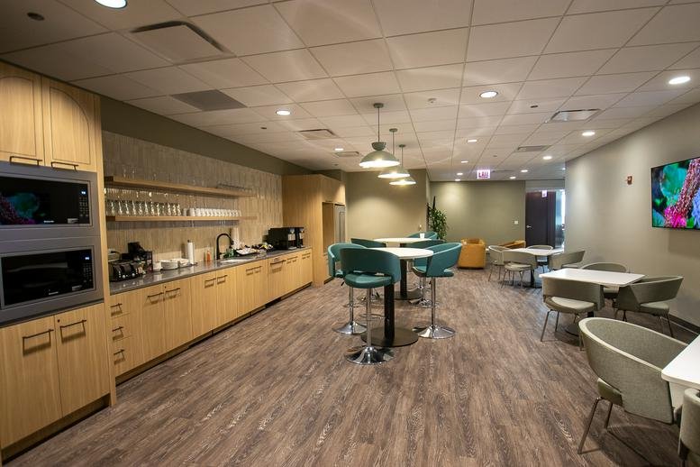 Reception lobby at 181 West Madison, Chicago featuring yellow armchairs and a digital screen.