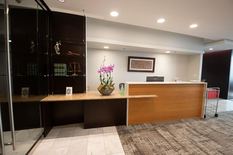 Professional reception area at 181 West Madison, Chicago with a warm wood desk and floral arrangement.