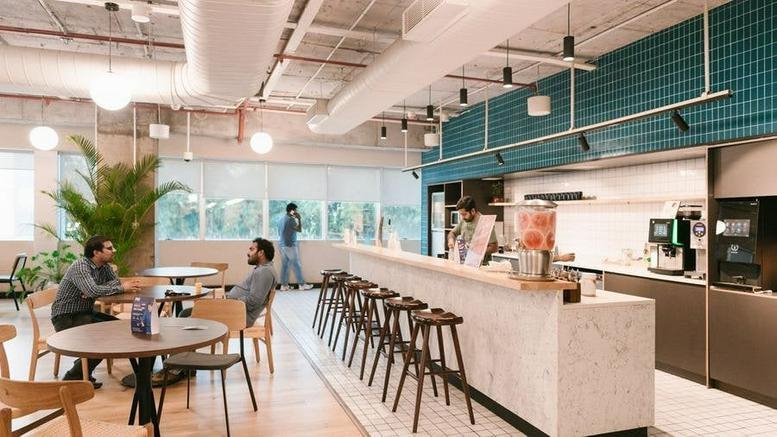 Bright communal cafe area with a marble-fronted bar, stools, and seating for 1825 South Grant St, San Mateo.