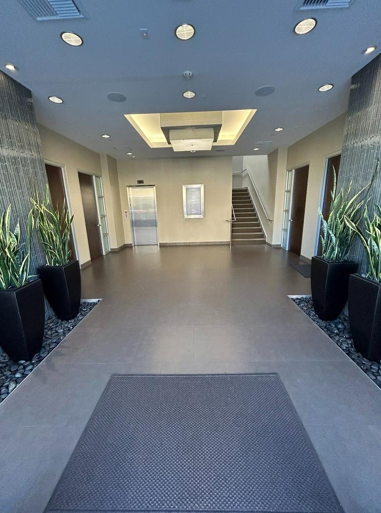 Spacious modern lobby at 18426 Brookhurst Street featuring indoor plants and a decorative recessed ceiling light.