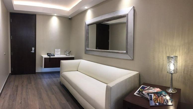 Waiting area at 18430 Brookhurst Street, Suite 202K with a white leather sofa and large silver-framed mirror.