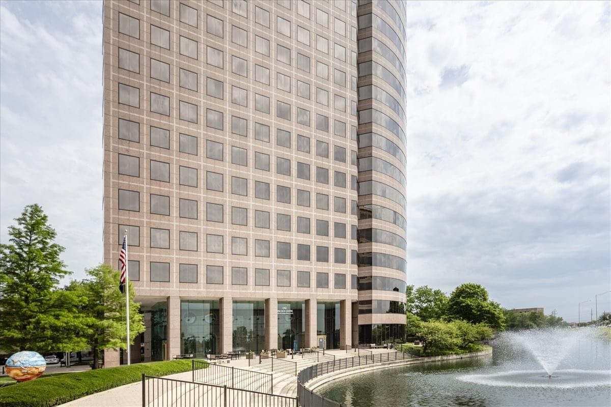 Exterior view of the high-rise facade at One Lincoln Centre overlooking a pond with a fountain.