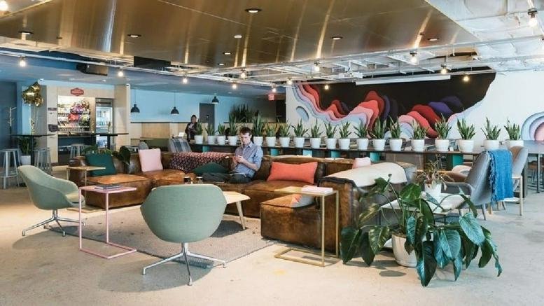 Spacious communal lounge at 1900 Market Street, Top Floor with colorful mural and potted plants.