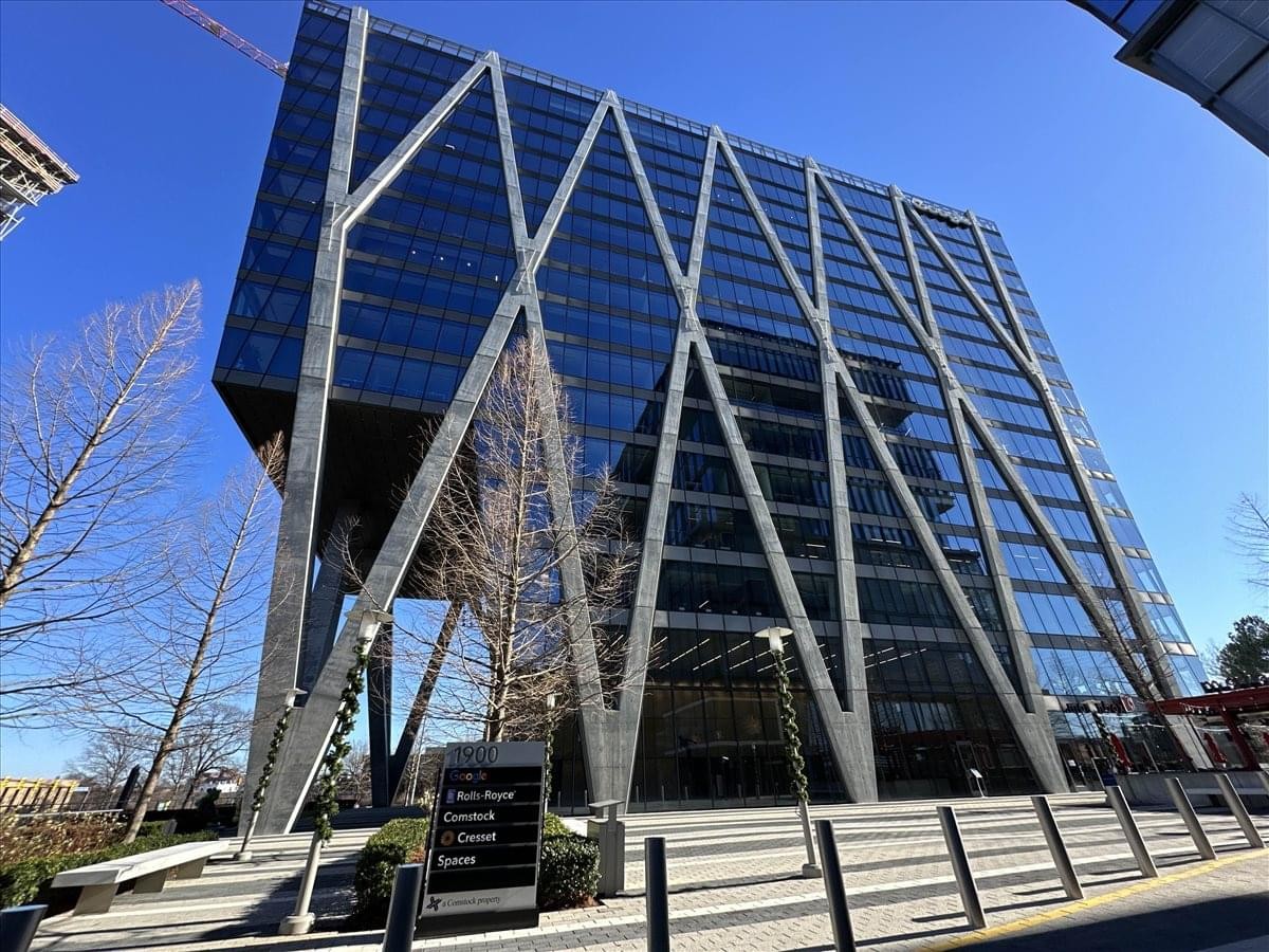 Modern glass exterior of the 1900 Reston Metro Plaza building with unique diagonal structural bracing.
