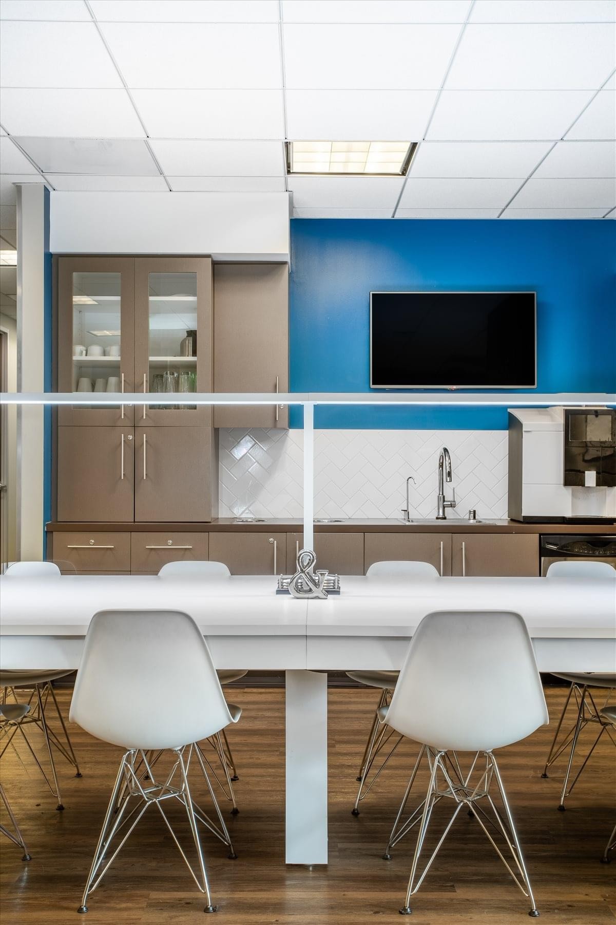 Modern breakroom kitchen at 1901 Harrison Street, Suite 1100, with a blue accent wall and white bar seating.