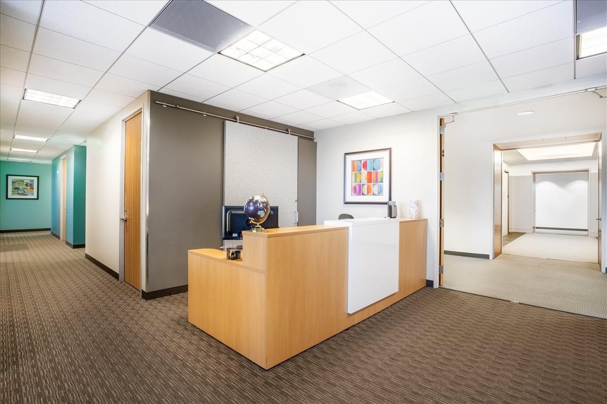 Reception desk at 1901 Harrison Street, Suite 1100 with light wood finishes and warm lighting.