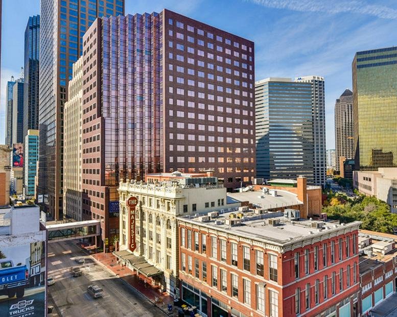 Exterior view of the historic 1910 Pacific Avenue building surrounded by downtown skyscrapers.