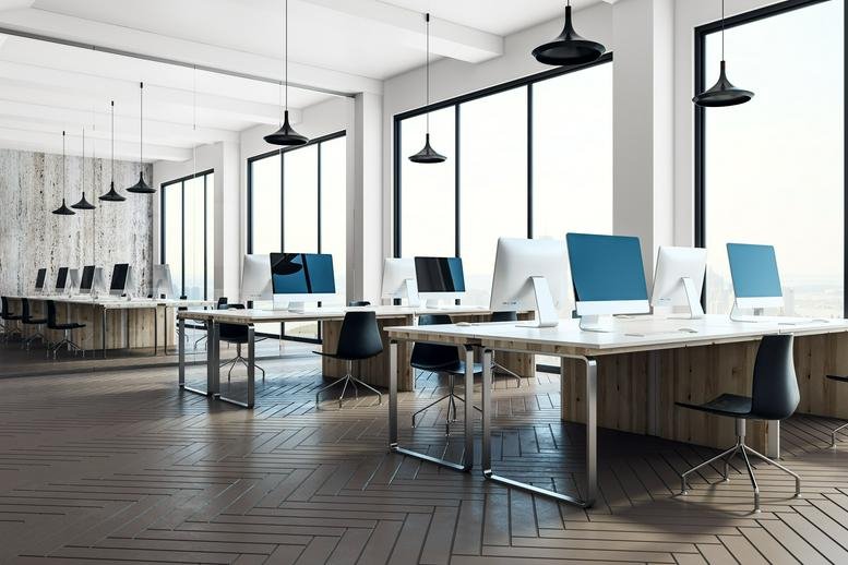 Spacious open-plan workspace at 195 Broadway, New York City with wooden desks and large industrial windows.