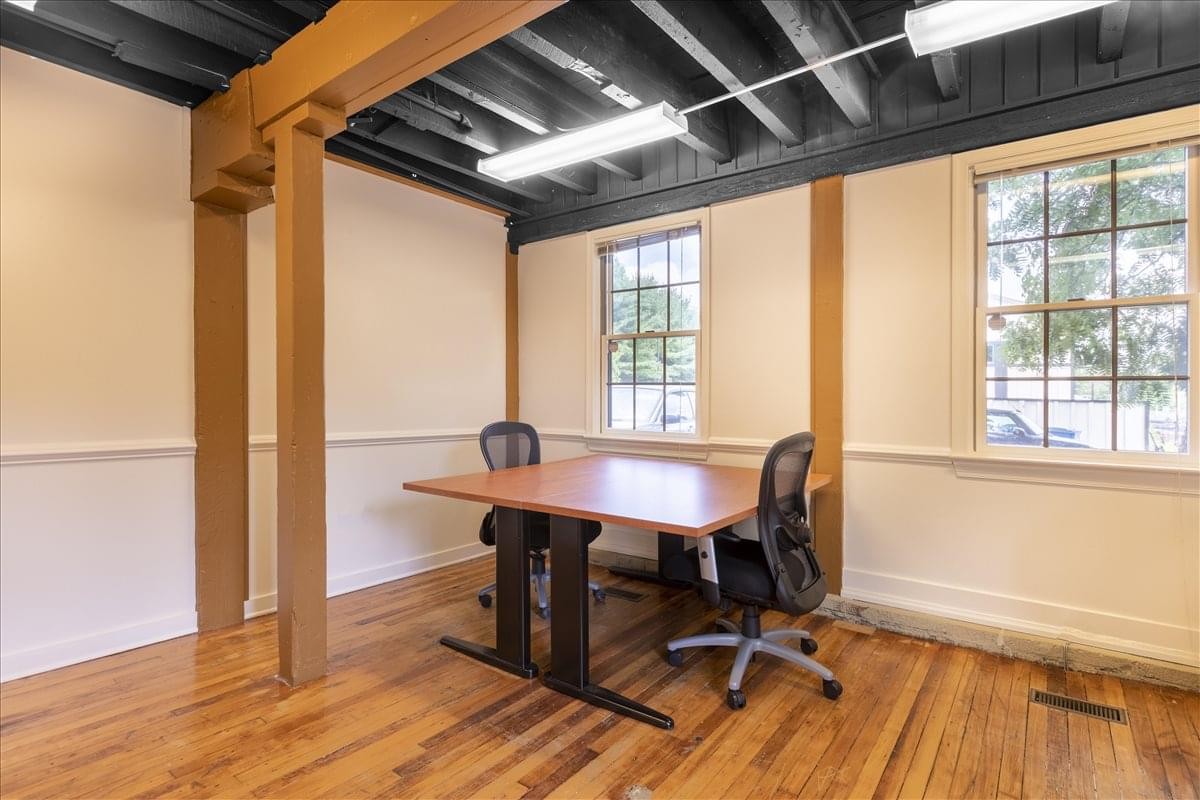 Co-working space at 196 West Ashland Street, 3rd Floor with wooden beams and natural light.